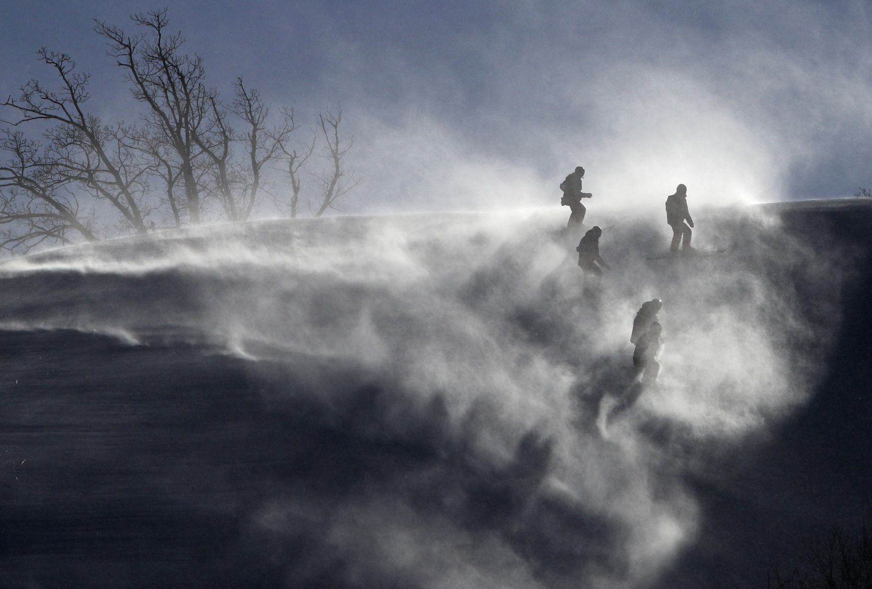 Course crew are shrouded in snow as they slip slide to the finish